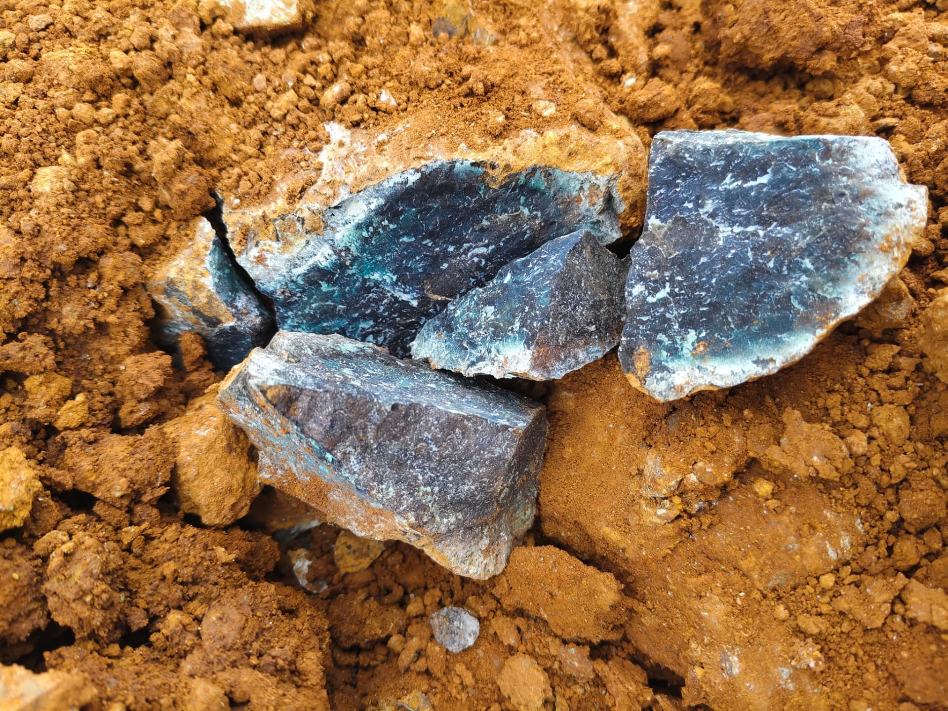 Nickel laterite ore fragments in red-brown Indonesian soil